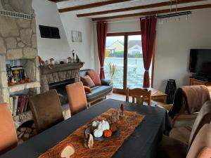 a living room with a table and a fireplace at Gite Les Hirondelles in Langatte