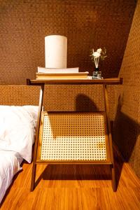 a side table with a bed and a table with books at CocoHaus in Batangas City +6 photos