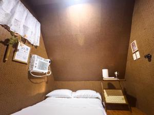 a bedroom with a bed and a fan on the wall at CocoHaus in Batangas City