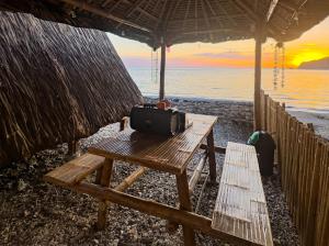 a picnic table on the beach with a suitcase on it at CocoHaus in Batangas City