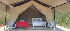 a tent with two chairs and a table in it at NATURE LOVERS ADVENTUREs in Maasai Mara National Reserve