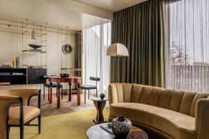 a living room with a couch and a table at The Dean Munich, Autograph Collection in Munich