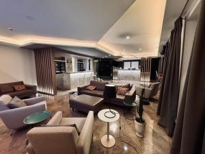 a living room with couches and chairs and a kitchen at Hotel Soret in Overijse