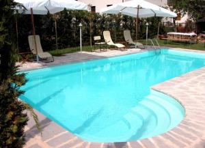 a large blue swimming pool with chairs and umbrellas at Monastery Birbino in Le Ville