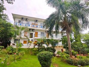 a building with a palm tree in front of it at Hotel Totara in Dar es Salaam