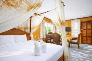 a bedroom with a bed with a canopy at Chatsuree Boutique Resort in Ubon Ratchathani