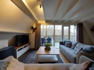 a living room with a couch and a table at Chalet 230 I Gezellig chalet aan de rand van het bos - 5 persoons I Durbuy in Durbuy