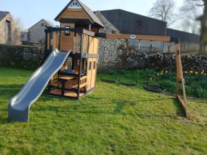 a playground with a slide and a swing at Old Coach House in Matlock