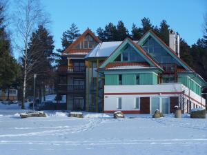 a large house with snow in front of it at Apartment Lipno in Lipno nad Vltavou