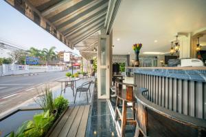 an outdoor bar with tables and chairs on a balcony at WUA LAI Boutique Hotel Chiang Mai in Chiang Mai