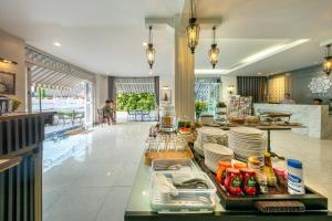 a restaurant with a counter with plates and food at WUA LAI Boutique Hotel Chiang Mai in Chiang Mai