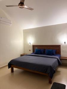 a bedroom with a large bed with blue pillows at Palm Paradise Resort in Revadanda