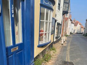 a blue door on a building with a window at The Bittern in Holt