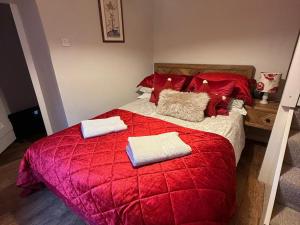 a red bed with two pillows on top of it at The Bittern in Holt