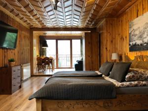 a bedroom with a large bed and a table at Willa Karolina Centrum Zakopane in Zakopane