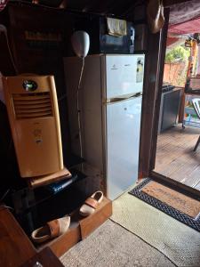 a kitchen with a refrigerator and a pair of shoes at Chalet en bois accés piscine in La Possession