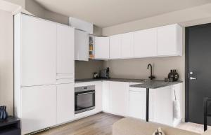 a white kitchen with white cabinets and a counter at Modern apartment with two bedrooms in Hektner