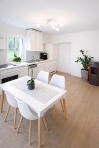 a kitchen with a white table and white chairs at Gemütliches Haus für Familien bis zu 7 Personen mit Parkplatz und ruhiger Lage in Selzthal