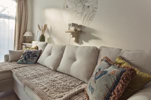 a white couch with pillows in a living room at Loft Amalia w wieży strażackiej, butikowy, blisko jeziora in Szczecinek