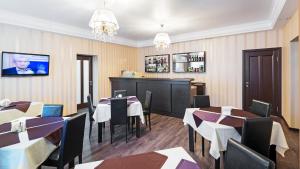 un restaurante con mesas y sillas y un bar en Hotel Zagreb, en Saratov