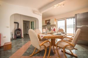 a dining room with a table and chairs and a fireplace at Villa Albatros in Vinišće