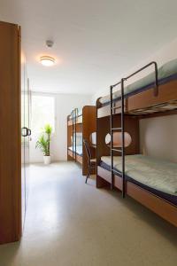 a dorm room with bunk beds and a hallway at Casa di vacanza Giovanibosco in Bosco Gurin