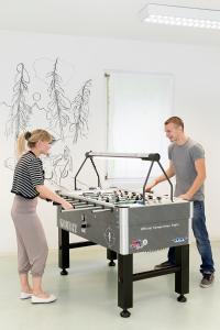 a man and woman standing next to a foosball table at Casa di vacanza Giovanibosco in Bosco Gurin