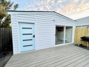 a white garage with a door on a deck at Private Barwon Heads Cottage Walk to River in Barwon Heads