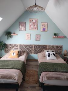 two beds in a room with blue walls at Gîte de l'écluse carrée in Coulogne +17 photos