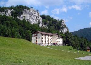 a building on a hill with a mountain in the background at Apartmán Olívia 8 Hrabovská dolina in Ružomberok