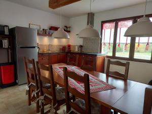 a kitchen with a table and chairs and a refrigerator at Maison de Vacances Tissendie in Bourg-de-Visa
