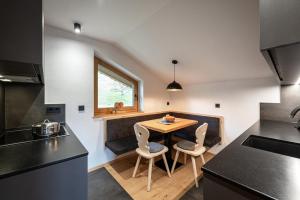 eine Küche mit einem Holztisch und Stühlen in der Unterkunft HAUSERHOF Farmhouse with Dolomite View in Villanders