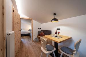 ein Zimmer mit Tisch und Stühlen und ein Schlafzimmer in der Unterkunft HAUSERHOF Farmhouse with Dolomite View in Villanders + 95 Fotos