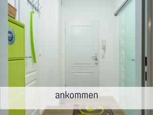 a room with a white door and a green refrigerator at Techt bi Strön 4 Sterne TOP-Fewo 2 WC Sauna Balkon Strand 5 Min Zentrum in Westerland