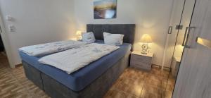 a bedroom with a bed with blue sheets and a lamp at Stiller Hafen in Herbolzheim