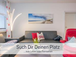 a living room with a couch and a red chair at Techt bi Strön 4 Sterne TOP-Fewo 2 WC Sauna Balkon Strand 5 Min Zentrum in Westerland