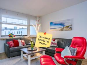 a living room with a couch and red chairs at Techt bi Strön 4 Sterne TOP-Fewo 2 WC Sauna Balkon Strand 5 Min Zentrum in Westerland +49 photos