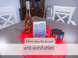 a bottle of wine and a sign on a table at Techt bi Strön 4 Sterne TOP-Fewo 2 WC Sauna Balkon Strand 5 Min Zentrum in Westerland