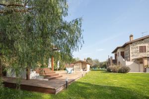a backyard with a wooden deck and a tree at Casale Elisa Country Hotel in Ladispoli