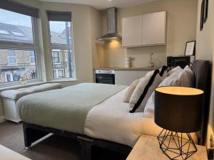 a bedroom with a large bed and a kitchen at Curzon St Aparthotel in Derby +51 photos