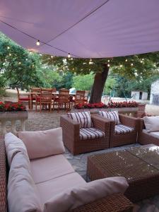 a patio with couches and chairs under a tent at Maison de Vacances Tissendie in Bourg-de-Visa