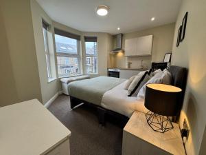 a bedroom with a large bed and a kitchen at Curzon St Aparthotel in Derby
