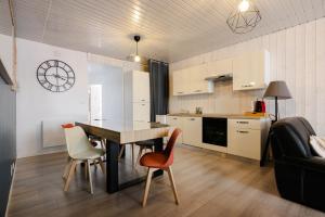 a kitchen and living room with a table and chairs at Le Reflet des Pyrénées in Bagnères-de-Bigorre
