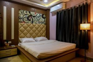 a bedroom with a bed with a headboard and a lamp at Fussed Over Retreat in Siliguri +35 photos