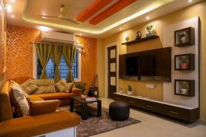 a living room with a couch and a tv at Fussed Over Retreat in Siliguri