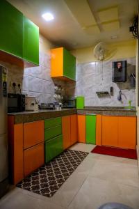 a kitchen with green and orange cabinets in a room at Fussed Over Retreat in Siliguri
