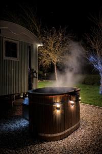 a hot tub with lights in a yard at night at Luxury Shepherds hut with wood fired hot tub on Lincolnshire Coast in Mablethorpe
