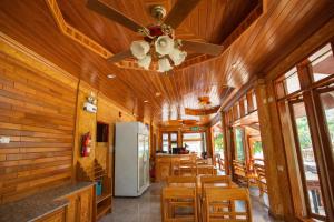 a dining room with a white refrigerator and wooden walls at Chatsuree Boutique Resort in Ubon Ratchathani