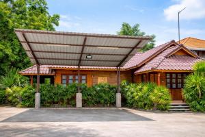 a house with a large roof on top of it at Chatsuree Boutique Resort in Ubon Ratchathani