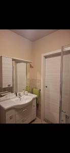 a bathroom with a sink and a shower with a mirror at Gg Home in Sirmione +7 photos